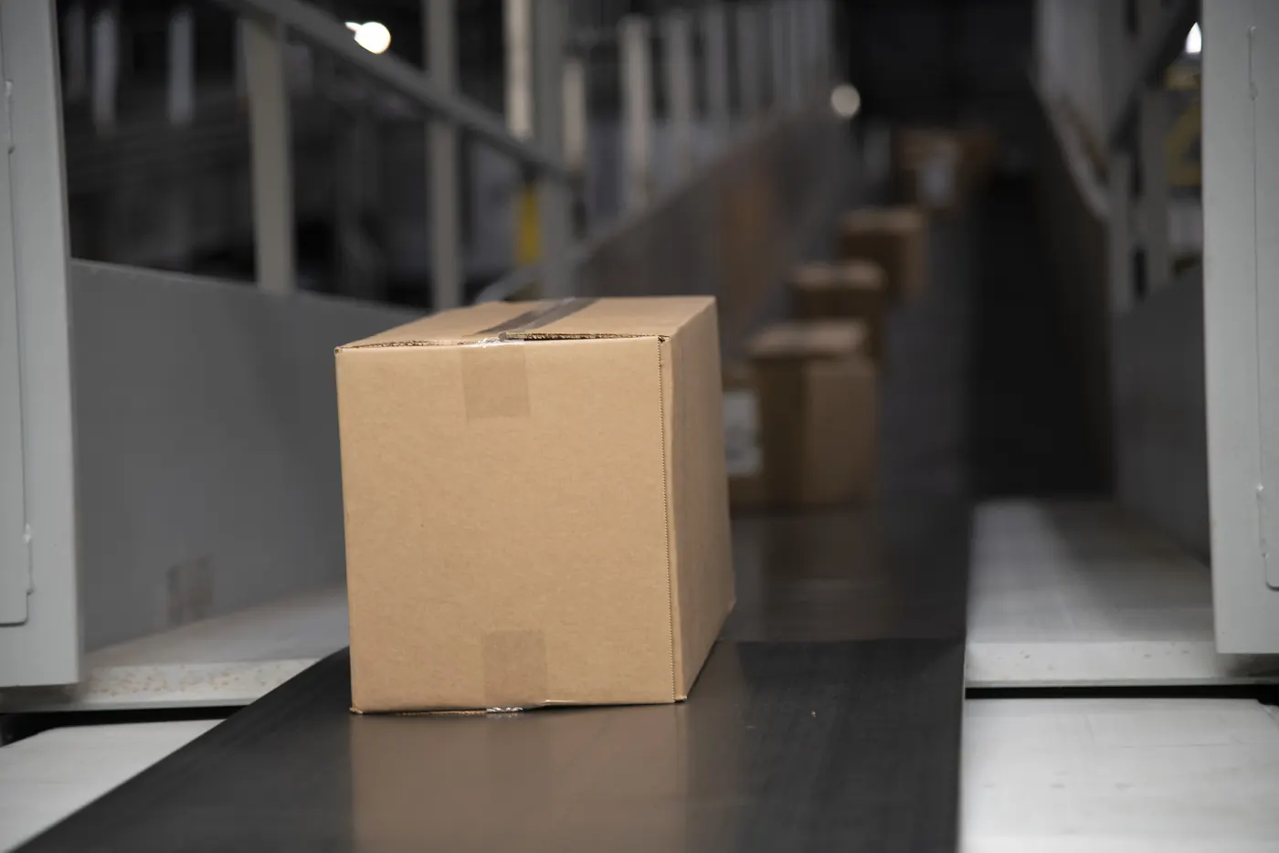 Cardboard parcel on a sorting conveyor ready for courier delivery