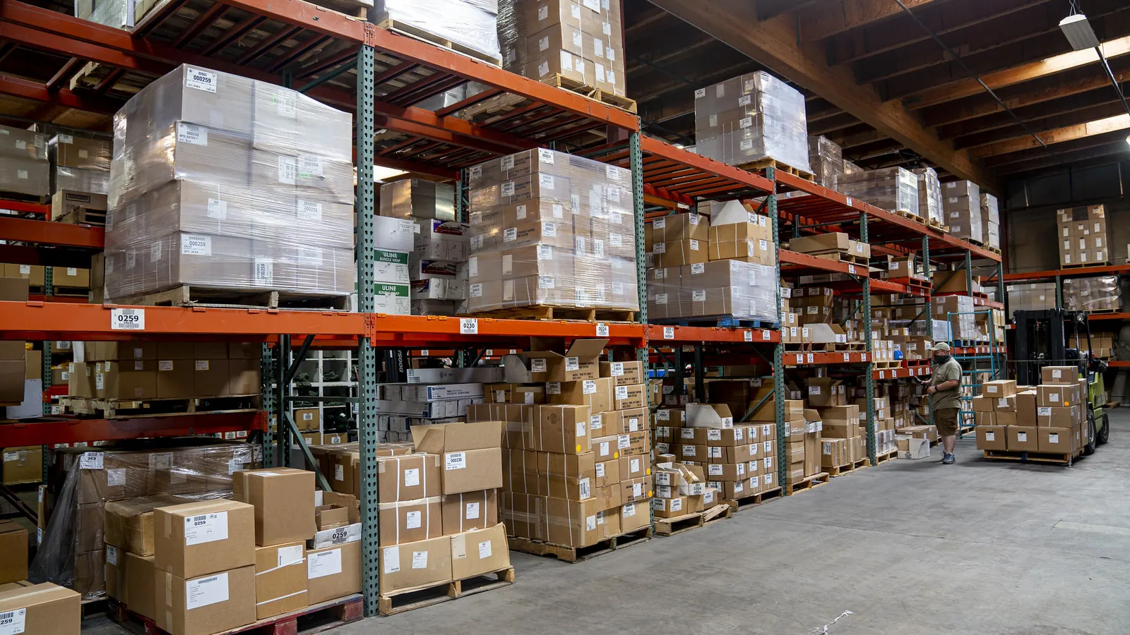 Warehouse racking stocked with palletised cartons and boxed goods